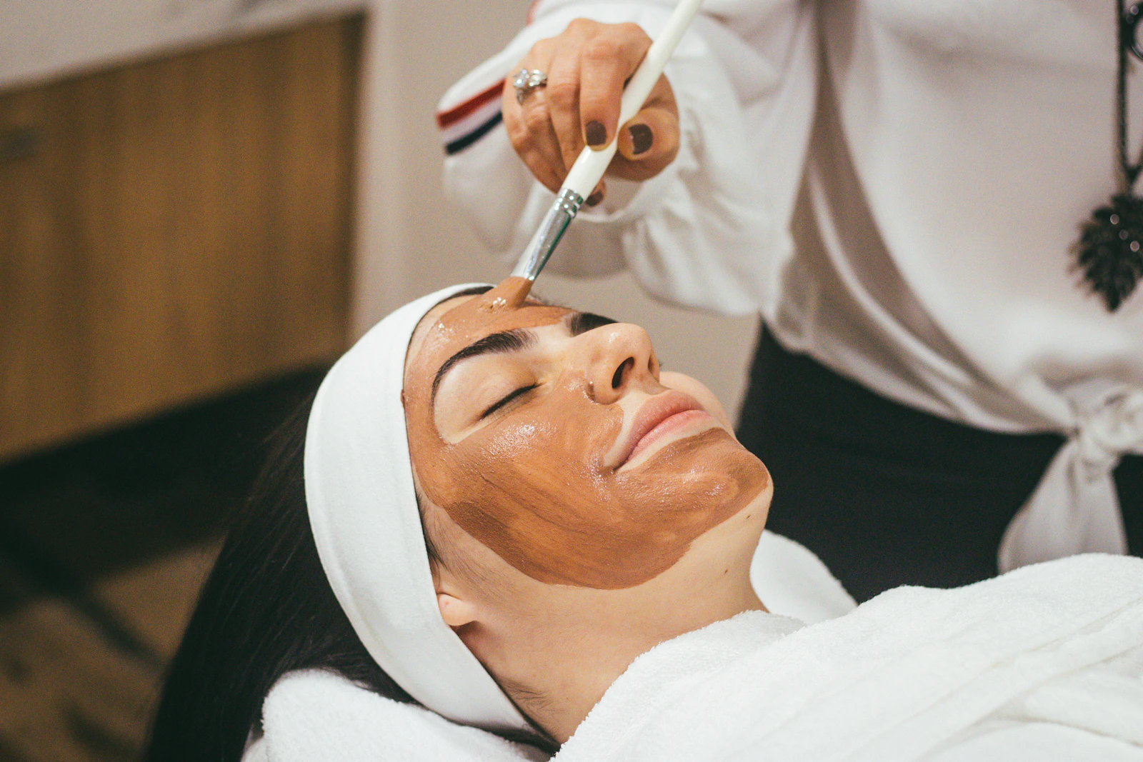 A client relaxing during a facial mask treatment at a spa