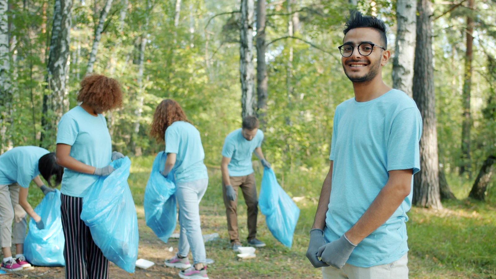 Volunteers in matching shirts cleaning up a park together