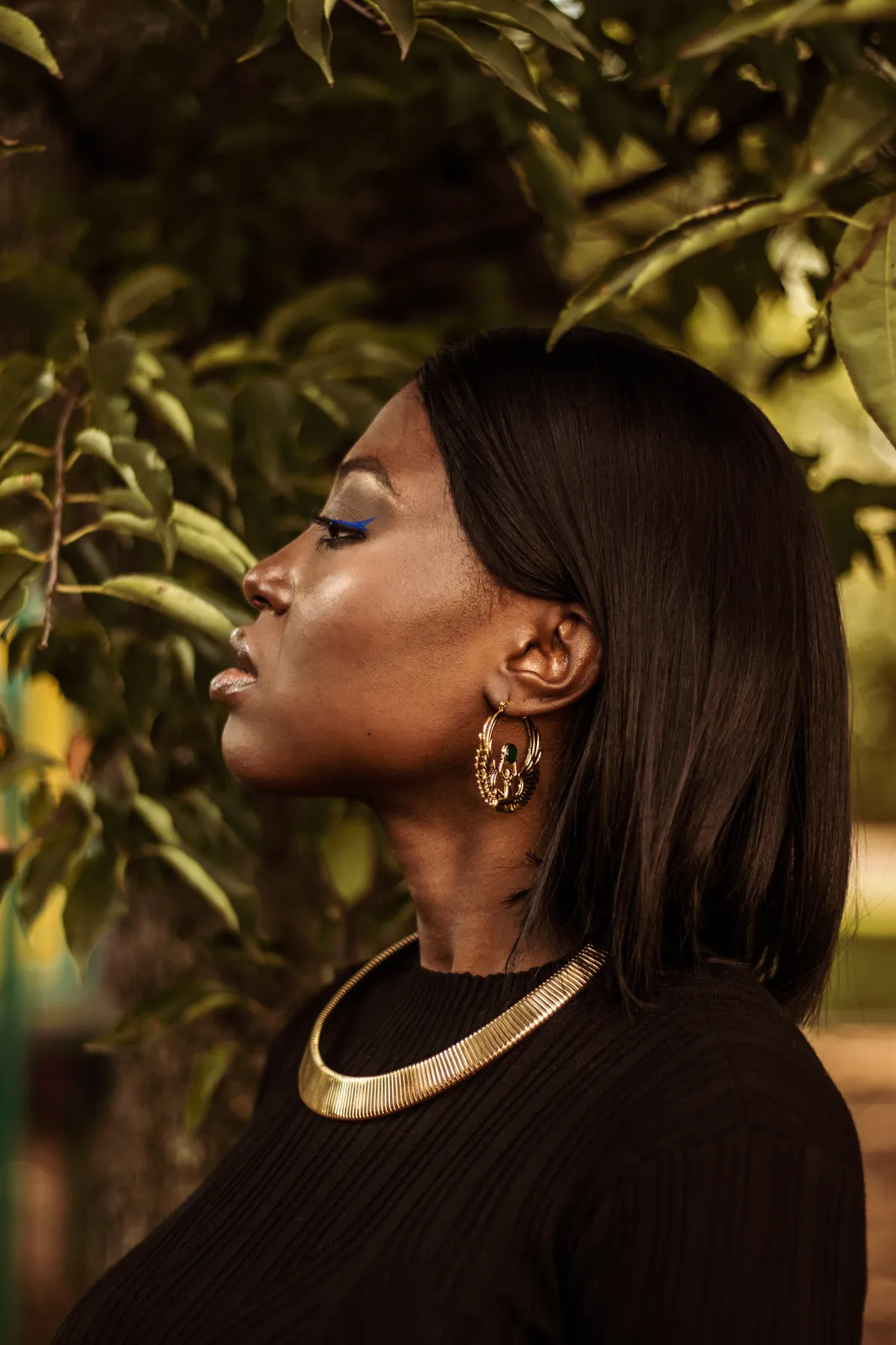 Golden hour profile portrait of a woman with a gold choker
