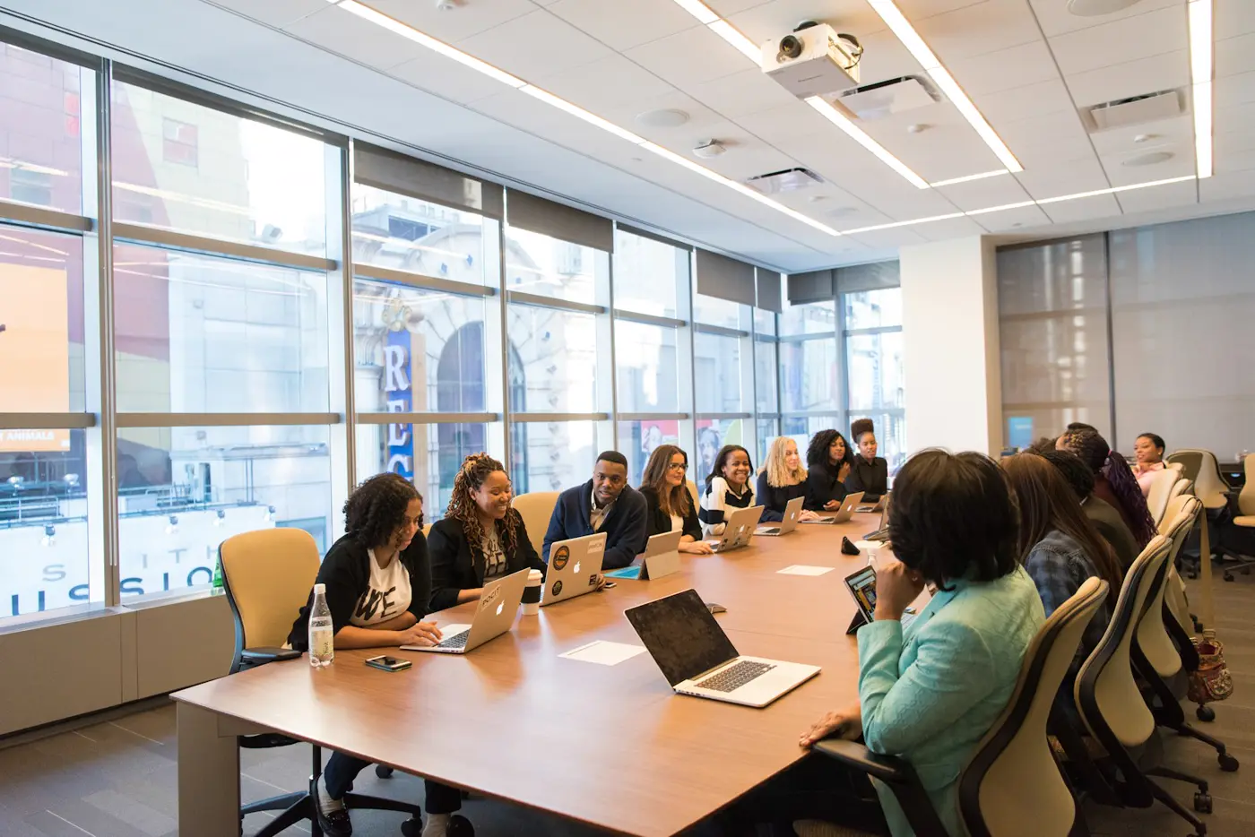 A group of young Black professionals working together on laptops around a conference table