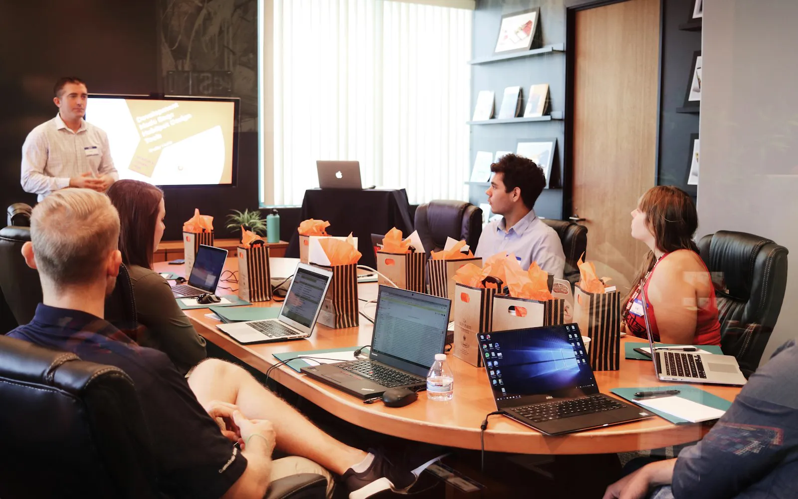 A presenter leading a training session for a team with laptops